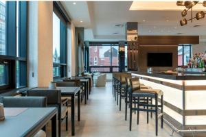 a restaurant with tables and chairs and a bar at AC Hotel by Marriott Burlington in Burlington