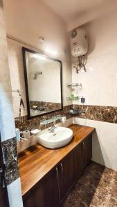 a bathroom with a sink and a large mirror at Riyansh Villa in Gwalior