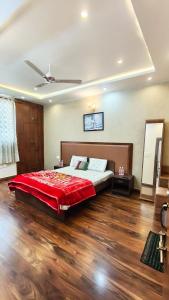 a bedroom with a large bed with a red blanket at Riyansh Villa in Gwalior