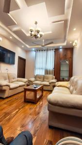 a living room with couches and a table at Riyansh Villa in Gwalior