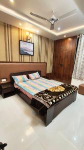 a bedroom with a bed with a tv on the wall at Riyansh Villa in Gwalior