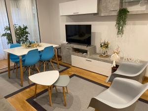 a living room with a table and chairs and a tv at Apartamento Ainaran Confortable apartamento en el centro de Orense in Ourense