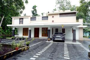 samochód zaparkowany przed domem w obiekcie PATHIRAMANAL Service Villas w mieście Alleppey