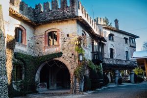 an old stone building with an archway on a street at La Locanda di Grazzano Visconti in Grazzano Visconti