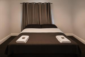 a bed with two towels on top of it at The Colliefields Hotel in Collie