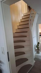 Una escalera en una casa con una escalera blanca. en Entspannung in Hasselborn, en Waldsolms
