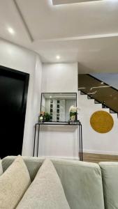 Una sala de estar con un sofá y una escalera. en XQUSITE APARTMENTs, en Lekki