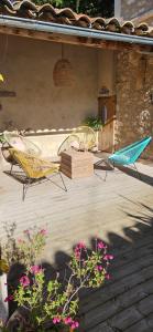 een patio met 2 stoelen, een tafel en bloemen bij Le nid douillet in Pertuis