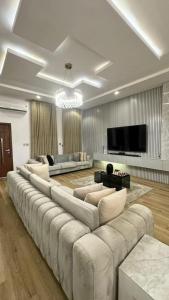 sala de estar amplia con sofá grande y TV en XQUSITE APARTMENTs, en Lekki 33 fotos más