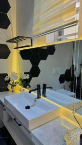 un baño con lavabo y espejo en XQUSITE APARTMENTs, en Lekki