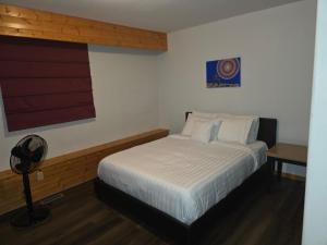 伊努维克Bujaks的卧室里有一张白色的床和一张书桌