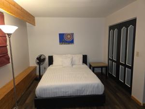 Bujaks في إنوفيك: غرفة نوم بسرير مع شراشف بيضاء ومصباح