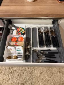 a drawer in a cabinet filled with utensils at Delta SPA Residence in Niš