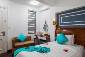 a bedroom with a bed with blue bows on it at Hanoi Cozy Boutique Hotel in Hanoi +17 photos