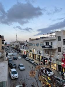 a busy city street with cars parked on the street at Classy Guesthouse in Madaba