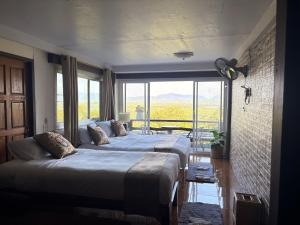 two beds in a room with a large window at BaanPhutawanLanta resort & cafe in Ko Lanta