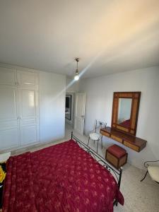 a bedroom with a red bed and a mirror at jawhara residency front view in Sousse +3 photos