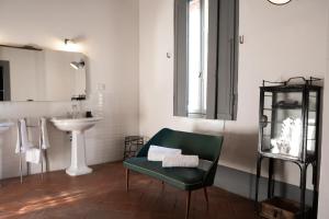 łazienka z zielonym krzesłem i umywalką w obiekcie La Locanda di Grazzano Visconti w mieście Grazzano Visconti