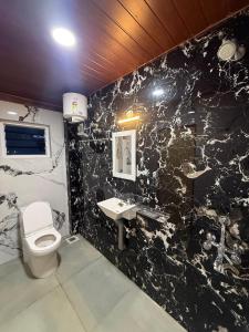 Pūrnānkuppamにあるle hut residencyの黒大理石のバスルーム(トイレ、シンク付) +6枚の写真