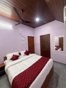 a bedroom with a large bed with a ceiling fan at le hut residency in Pūrnānkuppam