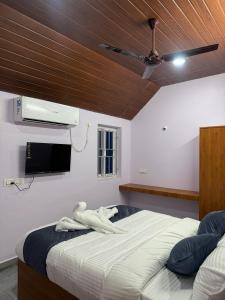 Pūrnānkuppamにあるle hut residencyのベッドと天井扇風機のある寝室
