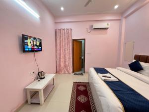 a bedroom with a bed and a tv on the wall at Hotel Vikrant Inn in Lucknow