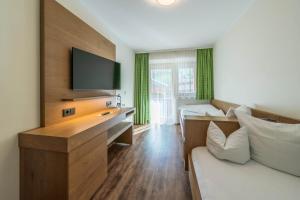 أكتيفهوتيل توكسيرهوف في زيل أم زيلر: غرفة معيشة مع أريكة وتلفزيون في غرفة