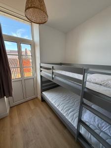 ラ・ロシェルにあるLe Rochelois by Maison ACGの二段ベッドが2つと窓のある部屋