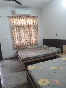 una habitación con dos camas y una ventana en Shiv Villa, en Jaipur