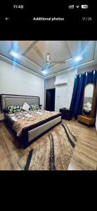 een slaapkamer met een bed en een grote spiegel bij Gill house in Multan