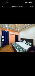 een slaapkamer met een groot bed en blauwe gordijnen bij Gill house in Multan