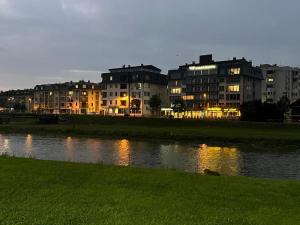 une ville avec des bâtiments et une masse d'eau dans l'établissement Ilidza Suite, à Sarajevo