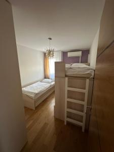 une petite chambre avec deux lits superposés et une fenêtre dans l'établissement Ilidza Suite, à Sarajevo