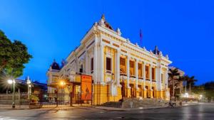 a large white building with stairs in front of it at Hanoi Cozy Boutique Hotel in Hanoi