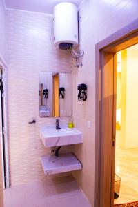 ein Badezimmer mit Waschbecken und Spiegel in der Unterkunft The Garden Inn نزل الحدیقة in Nizwa