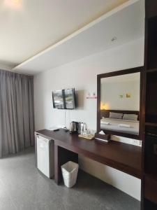 um quarto de hotel com uma secretária e um espelho em Doze Bangla em Patong Beach