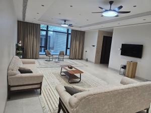 a living room with couches and a flat screen tv at Alwadi view شرفة الوادي in Nizwa