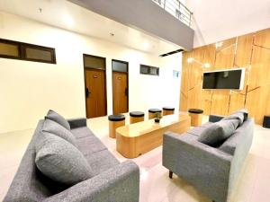 Una sala de estar con un sofá y un televisor en The Grand Hotel Ciamis, en Ciamis