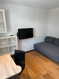 a living room with a bed and a tv on a wall at Central Hideaway in Maria Alm am Steinernen Meer