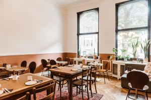 a restaurant with tables and chairs and windows at Boutique Hotel Marie Marie in Dendermonde