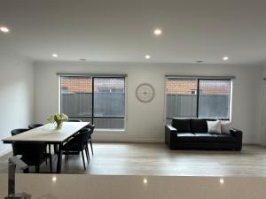 a living room with a table and a couch at Stunning 4 X Bed Holiday Home In Kalkallo! in Kalkallo