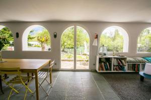 un soggiorno con finestre ad arco e tavolo di Les Nénuphars magnifique villa au bord du canal a Saint-Alban-de-Montbel
