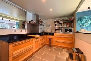 una grande cucina con armadi in legno e una grande finestra di Les Nénuphars magnifique villa au bord du canal a Saint-Alban-de-Montbel