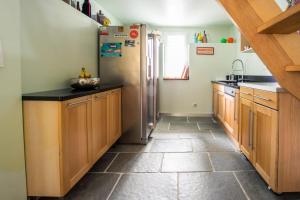 una cucina con frigorifero e pavimento piastrellato di Les Nénuphars magnifique villa au bord du canal a Saint-Alban-de-Montbel Altre 30 foto