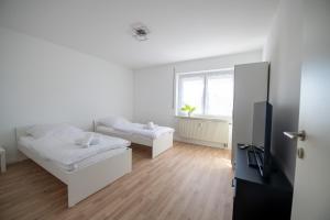 BiberbachW&P Living Wohnung mit Balkon Parkplatz的一间有两张床和一扇窗户的白色房间