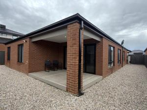 a brick house with a large open patio at Stunning 4 X Bed Holiday Home In Kalkallo! in Kalkallo