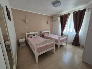 2 letti singoli in una camera con tende di Jolie Villa Santa avec piscine a Pointe-aux-Piments Altre 11 foto