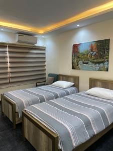 a room with two beds and a painting on the wall at Classy Guesthouse in Madaba