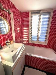 レンヌにあるWAROUX - Flat Rennes 6Pの赤いタイル張りのバスルーム(シンク、バスタブ付)