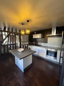 レンヌにあるWAROUX - Flat Rennes 6Pの白いキャビネットとテーブル付きの広いキッチン